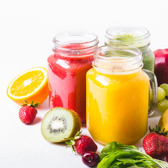 Selection of multicolored fruit smoothies  in glass jars