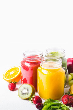 Selection of multicolored fruit smoothies  in glass jars.