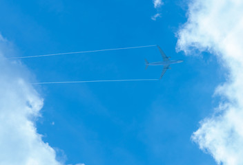 Airplane on blue sky and white clouds. Commercial airline flying on blue sky. Travel flight for vacation. Aviation transport.