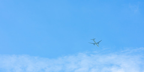 Airplane on blue sky and white clouds. Commercial airline flying on blue sky. Travel flight for vacation. Aviation transport.