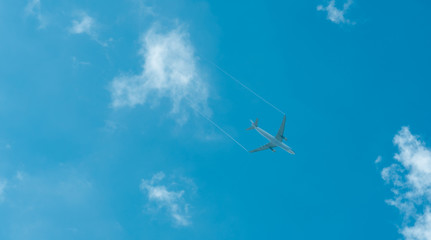 Airplane on blue sky and white clouds. Commercial airline flying on blue sky. Travel flight for vacation. Aviation transport.