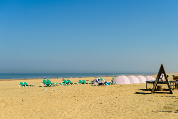 Fototapeta na wymiar Enjoying life. People relaxing on the sandy beach during vacatio