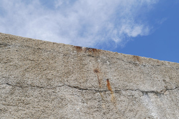 High concrete wall with blue sky on the top, no escape