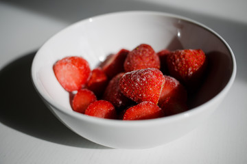  delicious, ripe, frozen strawberries in a white plate