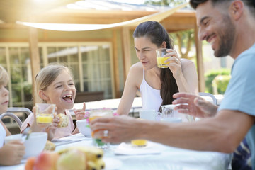 Family having breakfast in summer morning