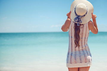 Urlaub am Strand, Frau mit Hut am Strand