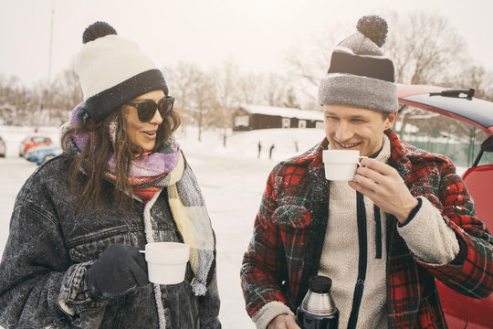 Couple In Winter Clothes Drinking Coffee