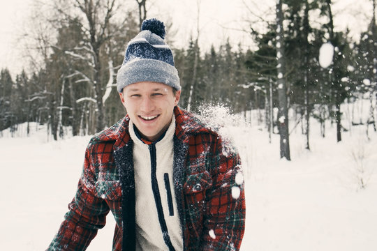 Portrait of happy mid adult man in warm clothing on snow covered field