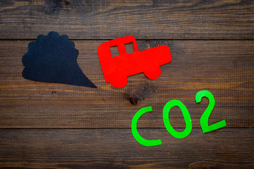 Car exhaust, co2, smoke. Car and smoke cutout on dark wooden background top view copy space