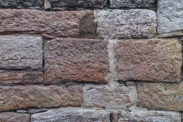 old stone wall of blocks of different colors close-up