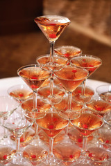Pyramid of champagne glasses with cherries