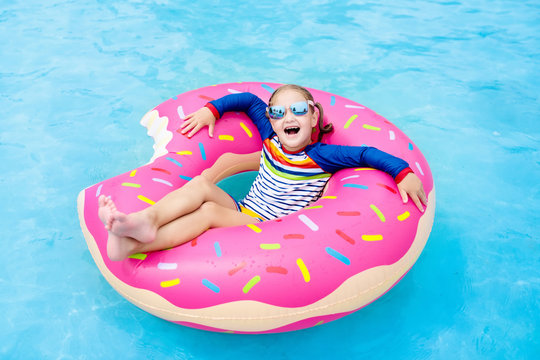 Child In Swimming Pool On Donut Float