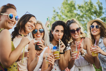 Group of female friends posing and having a good time at the outdoor party/music festival 