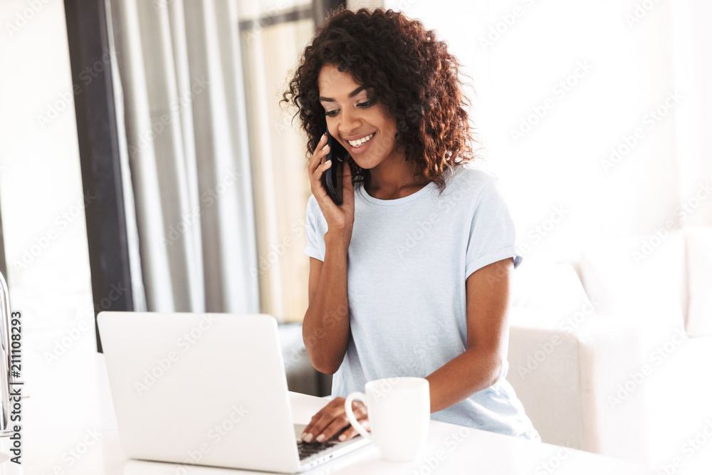 Wall mural smiling african woman talking on mobile phone