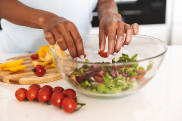 Obraz na płótnie Canvas Close up of a afro american woman making a salad