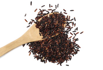 Organic black rice in wooden spoon isolated on white background, top view