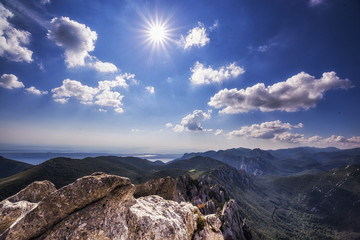Beautiful landscape sun in the mountains nature forest trees sky clouds green meadow in Velebit, Croatia