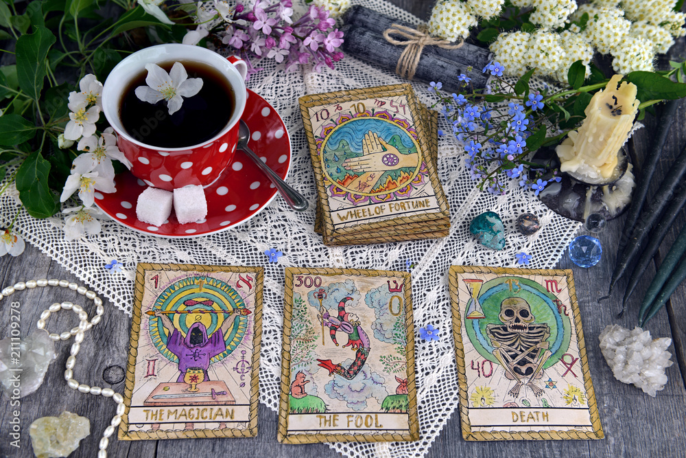 Wall mural tarot cards with cup of tea, flowers and black candles on planks. occult, esoteric and divination st