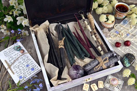 Witch box with hand made candles, crystal, runes, flowers and magic objects. Occult, esoteric and divination still life. Halloween background with vintage objects and magic ritual