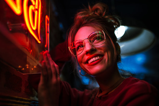 Cheerful woman at neon sign