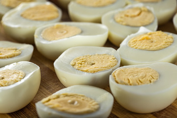 Slices of boiled hard eggs on a wooden cutting board