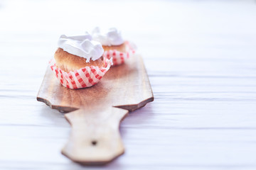 Naklejka premium Cupcakes with white cream on a wooden background