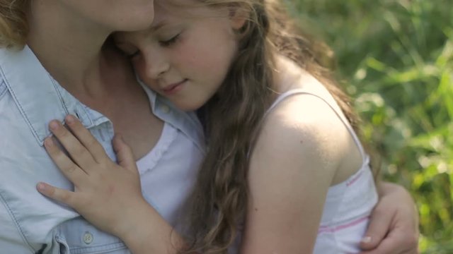 Blonde mother and child, girl sitting in embrace, enjoy each other. Tenderness