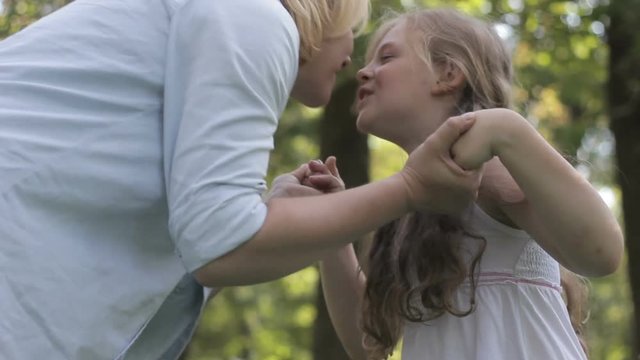 Surprised mother and daughter meeting, linking hands and kissing affectionately.
