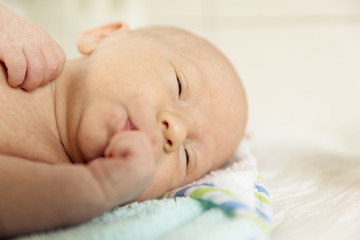 Cute newborn baby boy sleeps in a nursery while changing diapers