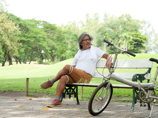 Senior man take a rest in Park after cycling .Health care concept.