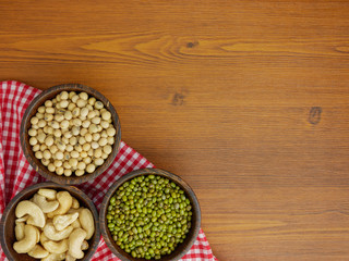 Obraz na płótnie Canvas Flat lay,top view assorted beans included cashews green beans and soybeans on wooden table with copy space