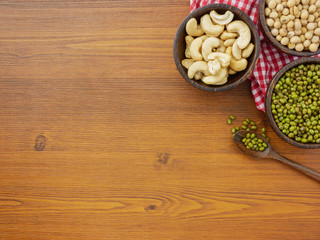 Flat lay,top view assorted beans included cashews green beans and soybeans on wooden table with copy space