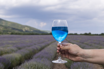 Mand holding a glas of blue wine