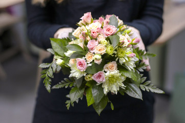 The work of the florist is a beautiful bouquet with roses and plants. Bridal bouquet, close-up. Work in a flower shop