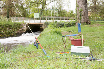 Obraz premium little fisherman corner at the river edge with the equipment and fishing rod