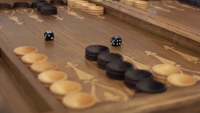 Hand throws dice on a backgammon board, 4k