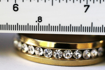 Gold ring with diamonds and a measuring instrument, so close