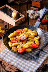 gnocchi baked with green pesto, cherry tomatoes and parmesan