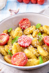 gnocchi baked with green pesto, cherry tomatoes and parmesan