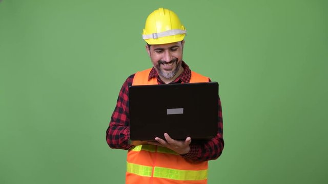 Handsome Persian bearded man construction worker using laptop