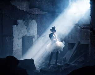 girl in a skirt of packing bags is standing in an abandoned building. Concept inspiration in creativity