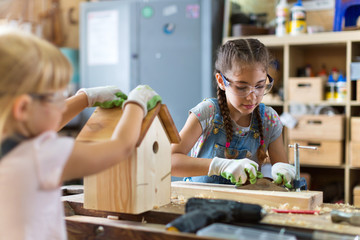 Two young girls doing woodwork in a workshop
