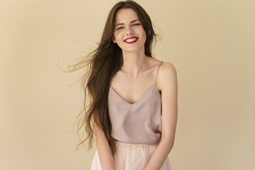 Fototapeta premium portrait of beautiful smiling young woman on beige background
