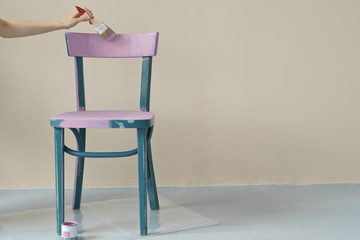  woman's hand painting chair in pink at home