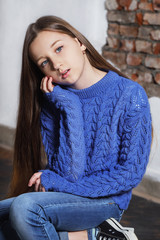 Portrait stylish model child. Beautiful teenager in blue sweater. Fashion pose model. Young hipster...