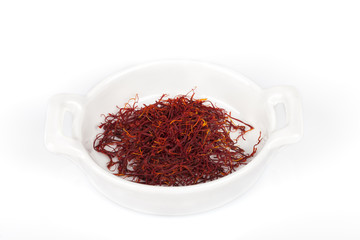 A pile of saffron inside a container isolated on white