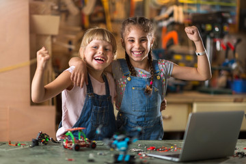Small girls building toy construction machine
