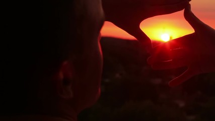 Close up of man hands making frame gesture with sunset. Future planning
