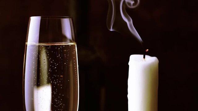 Cinemagraph. A glass of champagne away next to a candle that has recently been put out