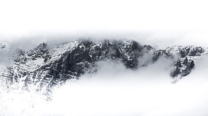 Face of the mountain surrounded with mist and clouds.